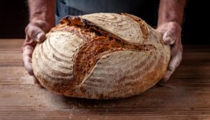 traditional leavened sourdough bread with rought skin rustic wooden table healthy food photo