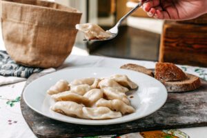 front view dough meal with minced meat inside salted peppered eastern dish along with bread loafs cuisine meat brown wooden desk