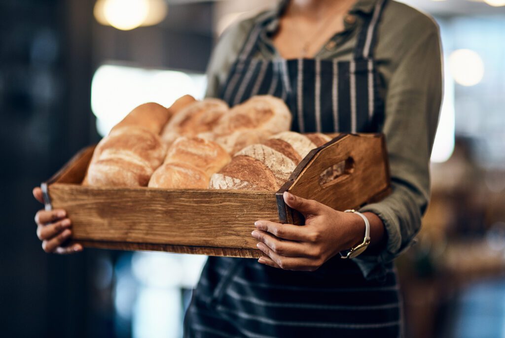 bakery basket hands waitress with bread serving food products pastry small business restaurant cafeteria person service help baked goods hospitality store