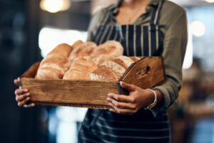 bakery basket hands waitress with bread serving food products pastry small business restaurant cafeteria person service help baked goods hospitality store