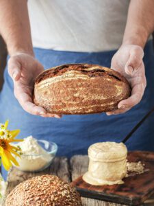 baker holds homemade craft bread his hands