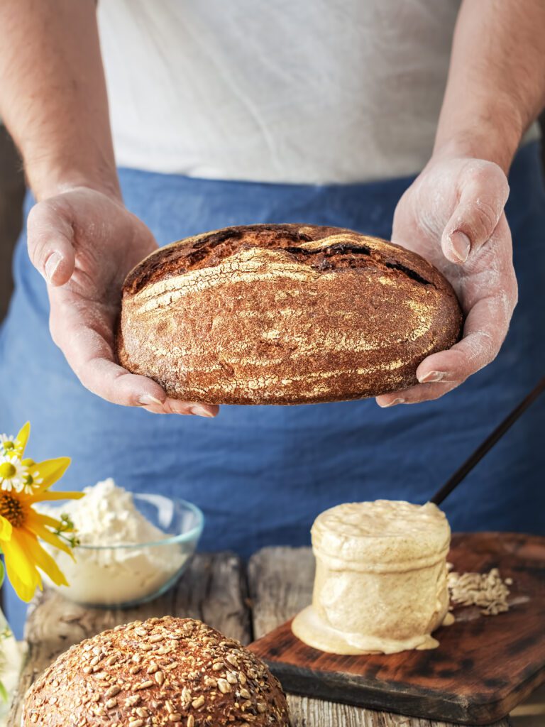 baker holds homemade craft bread his hands