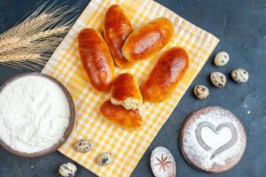 top view breakfat rolls kitchen towel flour bowl quail eggs heart imprint powdered sugar table