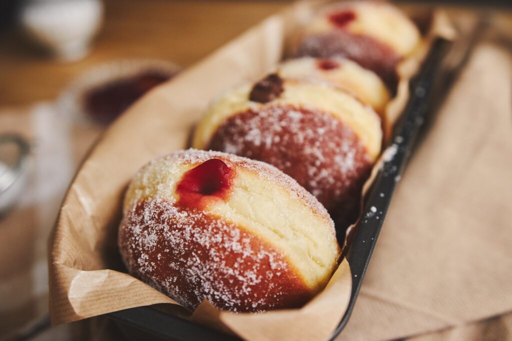 closeup fluffy doughnuts with jam container lights