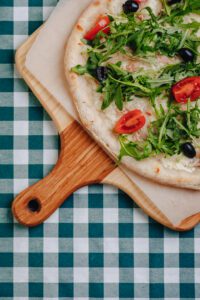 neapolitan pizza with tuna cheese arugula basil tomatoes olives sprinkled with cheese